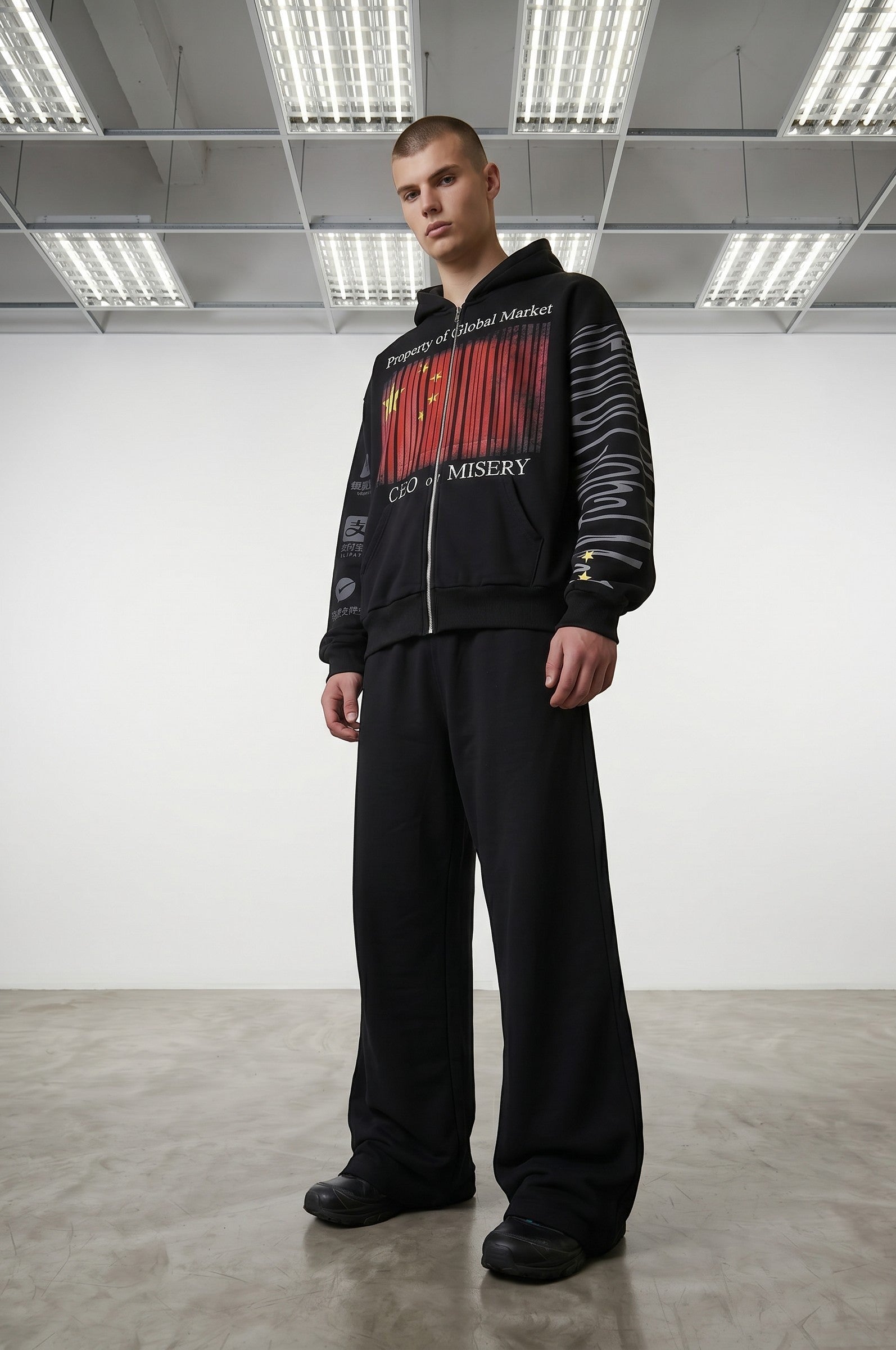 Estudio Mora black zip-up hoodie with graphic print of Chinese flag barcode and text "CEO of MISERY"
