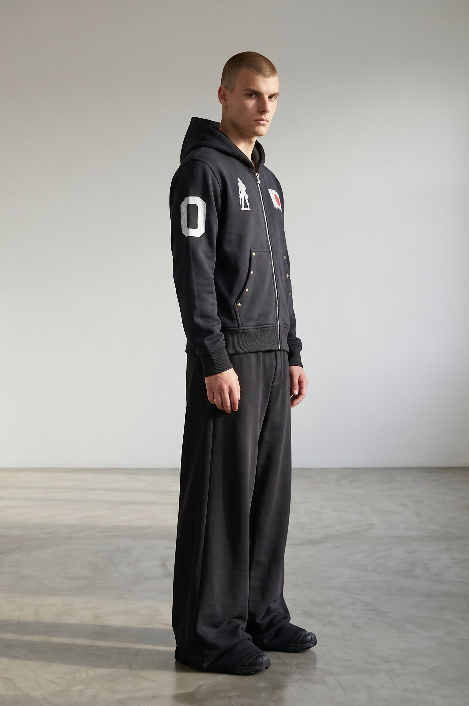 Sudadera con cremallera negra de algodón de Estudio Mora con estampado de número 0 y bandera japonesa en la manga.