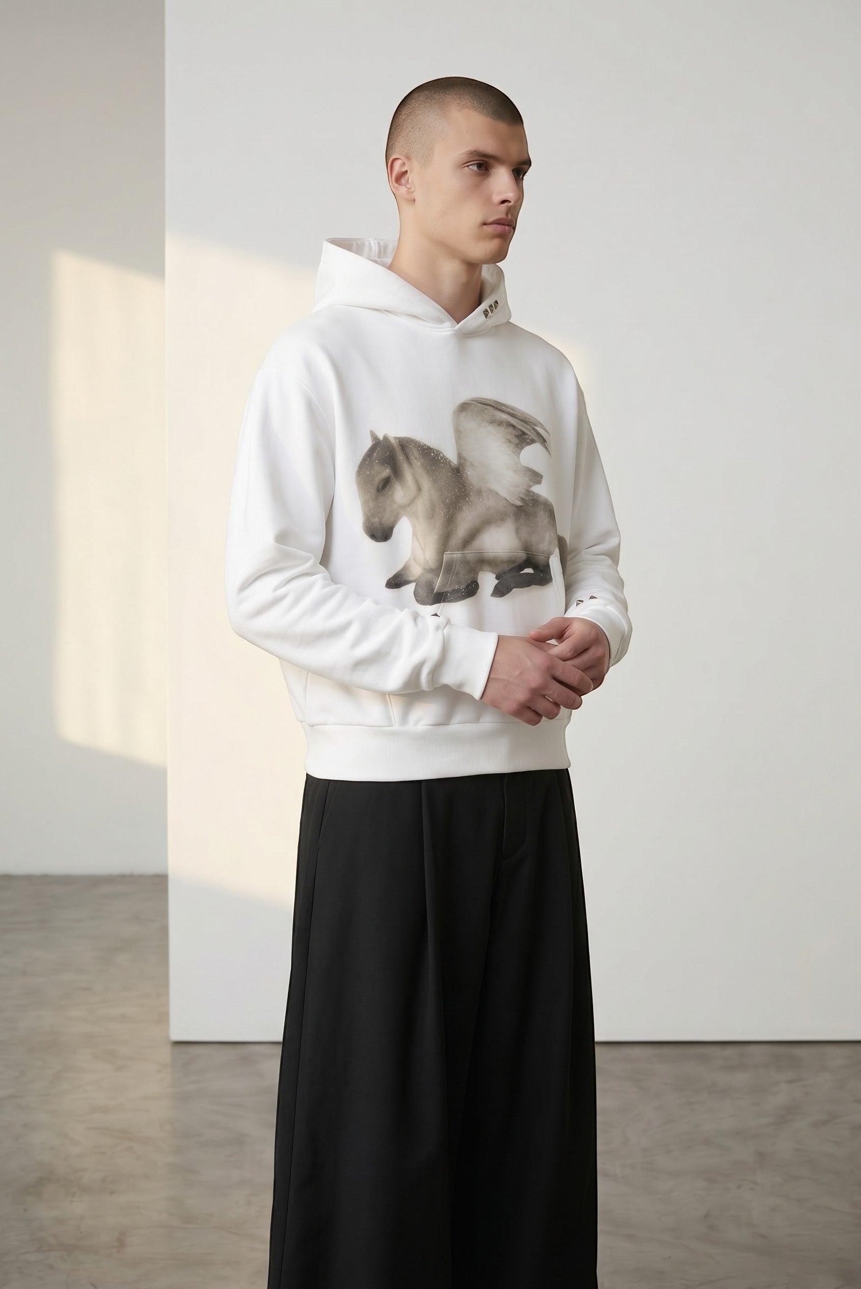 Sudadera con capucha blanca de algodón de Estudio Mora con estampado de caballo alado en el pecho. Modelo masculino.