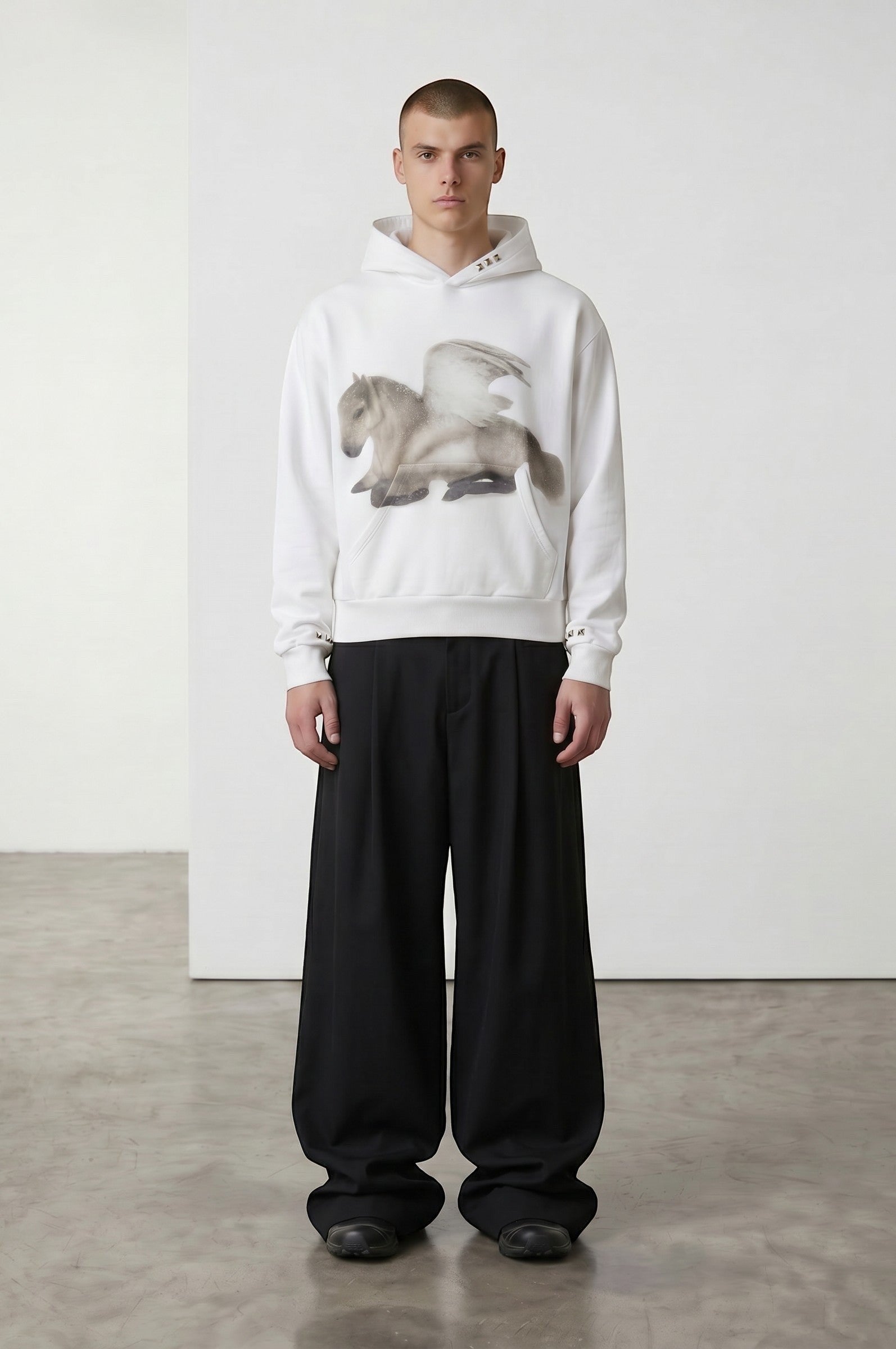 Sudadera blanca con capucha de Estudio Mora con estampado de caballo alado en el pecho y detalles de marca en las mangas.