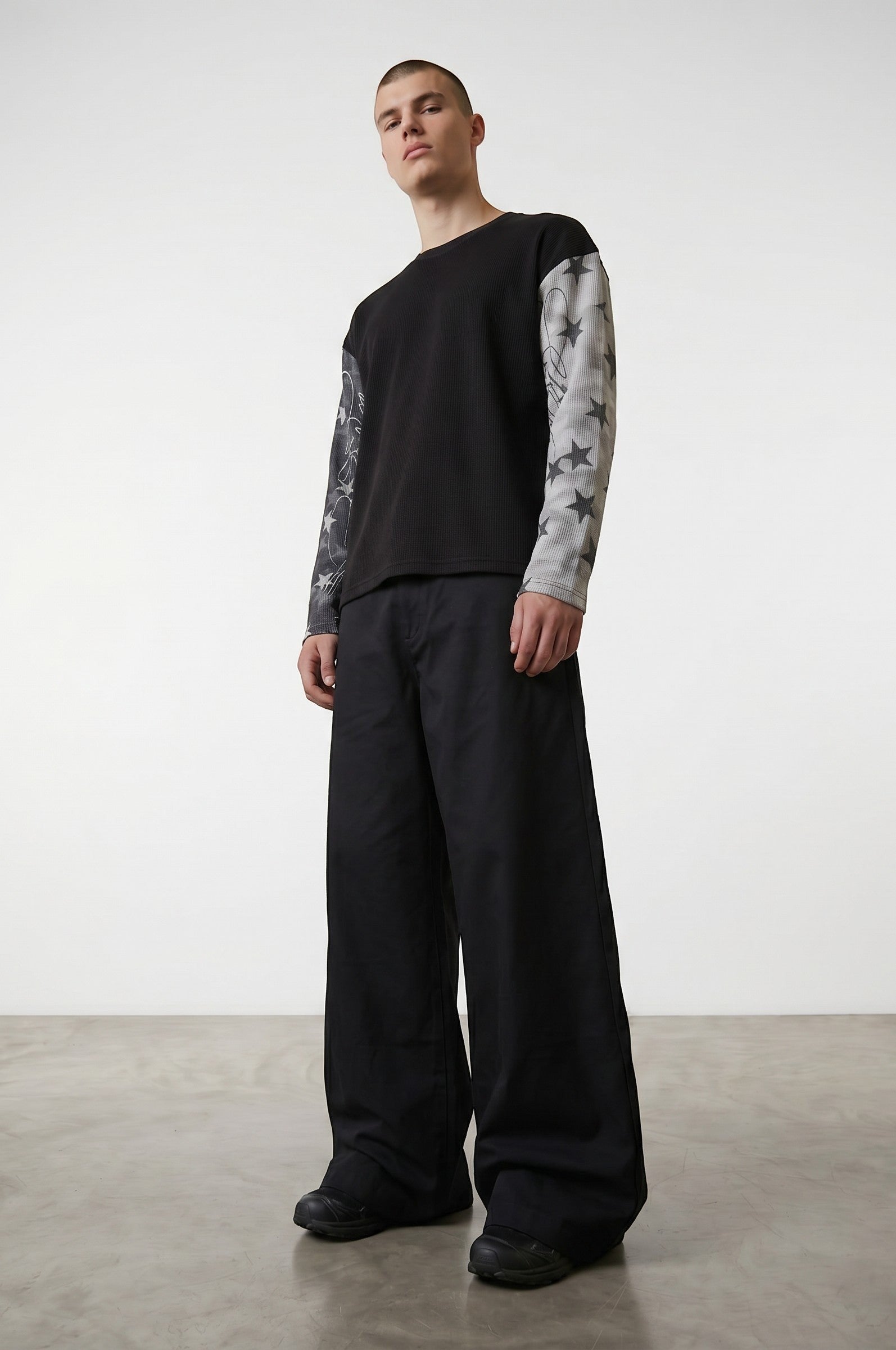 Sudadera negra de manga larga de Estudio Mora con estampado de estrellas en las mangas y cuello redondo.