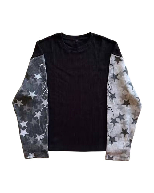 Sudadera negra de manga larga de Estudio Mora con estampado de estrellas grises y blancas en las mangas y detalle de remolinos.