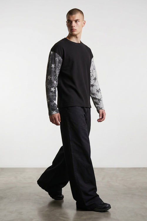 Estudio Mora sudadera negra de manga larga con estampado de estrellas en las mangas y tejido texturizado.
