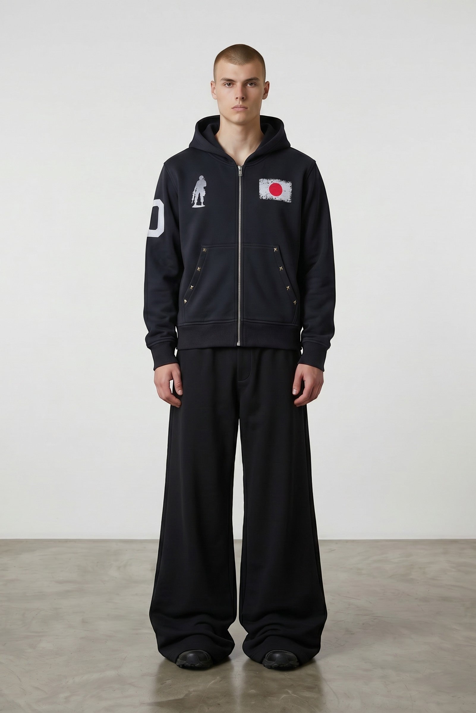 Estudio Mora sudadera con cremallera negra con estampado de la bandera de Japón y figura de soldado, mangas con detalle de número.